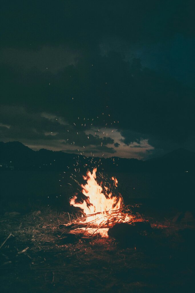 A peaceful campfire burning brightly under a starry sky in Colibița, Romania, creating a warm and cozy atmosphere.